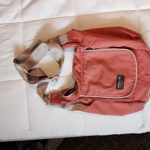 Pink crossbody purse with lots of pockets.